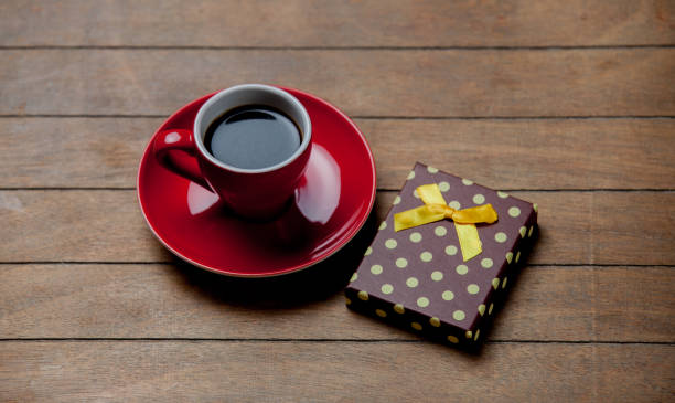 istock Cup of coffee with gift box on wooden background 926010894