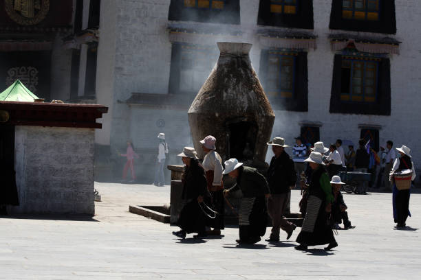 Jokhang Monastery, Lhasa, China - August 04, 2008: Tibetan old men rolling in their hand a traditional Buddhist prayer wheel in Jokhang Monastery, Lhasa, China