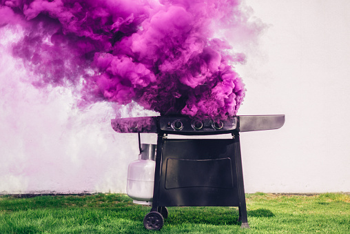 Purple smoke coming out of portable barbecue grill