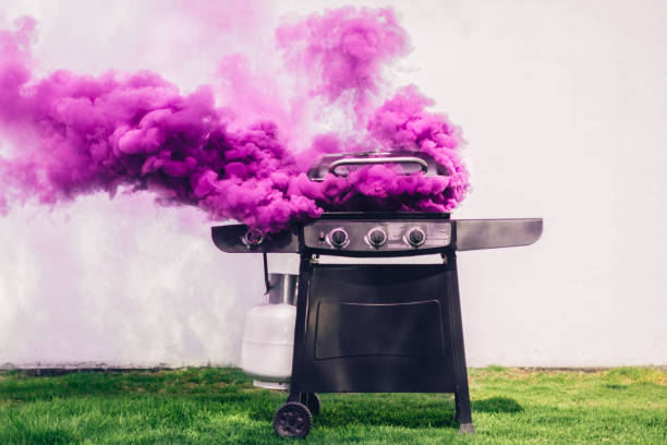 Smoking Barbecue Purple smoke coming out of portable barbecue grill appliance photos stock pictures, royalty-free photos & images