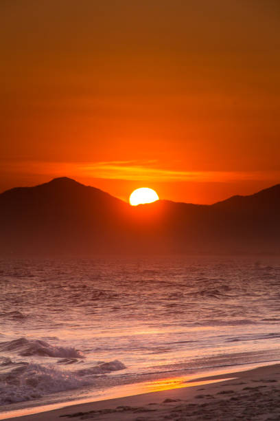 istock orange sunset behind the mountains by the sea 926033948