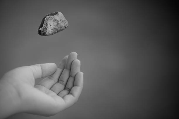 young woman hand throwing stone - throwing people stone tossing imagens e fotografias de stock