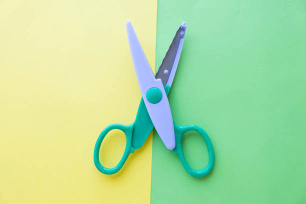 scissors cutting on pink paper background