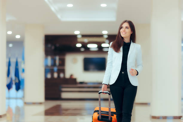 elegante donna d'affari con bagaglio trolley da viaggio nella hall dell'hotel - travel people traveling business travel vacations foto e immagini stock