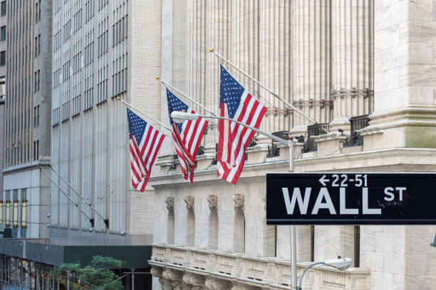 Wall street sign in New York City with New York Stock Exchange background. Wall Street sign with american flags and New York Stock Exchange in Manhattan, New York City, USA. wall street lower manhattan photos stock pictures, royalty-free photos & images