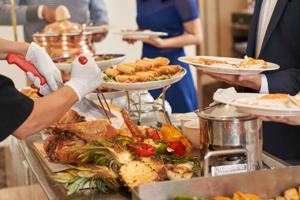 Buffet Cropped imaged of waiter cutting turkey for guests buffet stock pictures, royalty-free photos & images