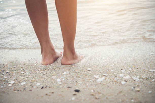 istock Young woman standing on the beach with barefoot. 926070552