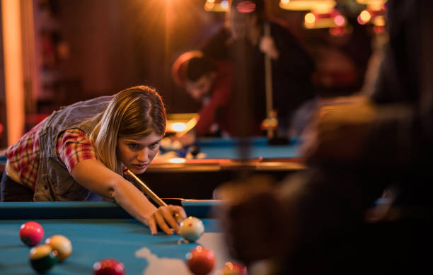 istock Concentrated woman aiming at the ball while playing billiard. 926074524