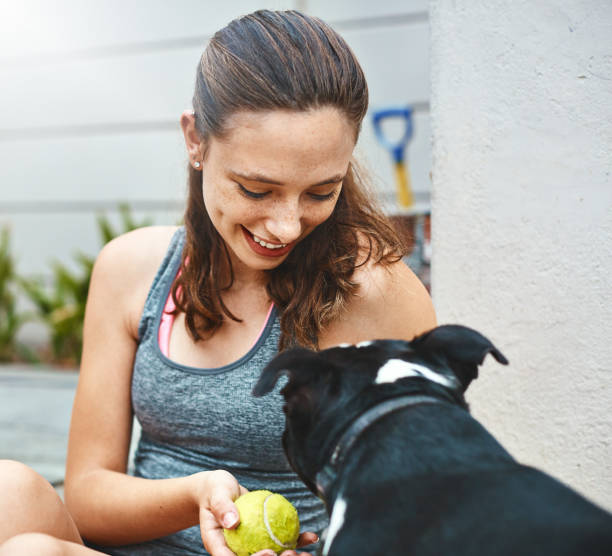istock Pretty girl looks down at her pet dog, smiling affectionately 926074990