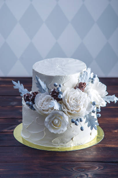 istock Delicate white bunk wedding cake decorated with an original design using mastic roses. Concept of festive desserts 926077080