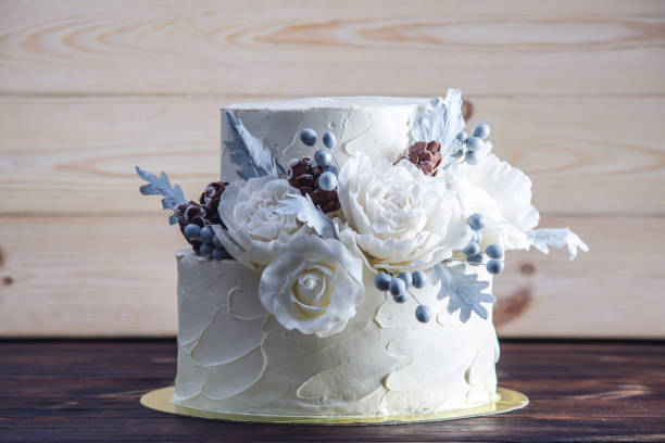 istock Delicate white bunk wedding cake decorated with an original design using mastic roses. Concept of festive desserts 926077088
