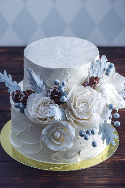 istock Delicate white bunk wedding cake decorated with an original design using mastic roses. Concept of festive desserts 926077090