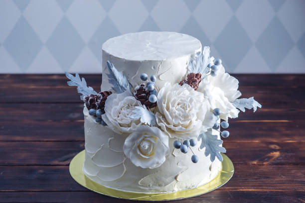 istock Delicate white bunk wedding cake decorated with an original design using mastic roses. Concept of festive desserts 926077092