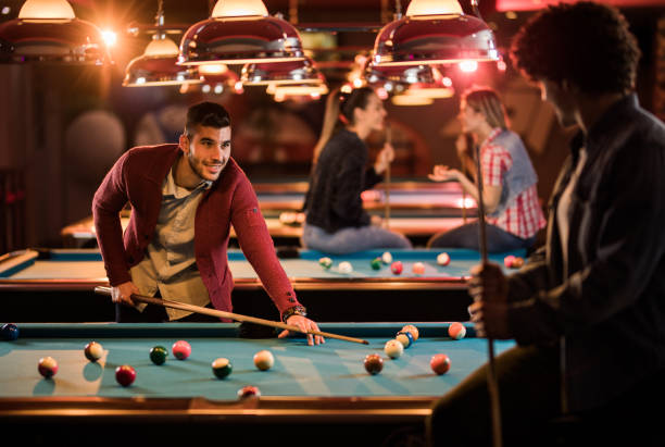 istock Happy man talking to his friend while playing snooker in a bar. 926077544