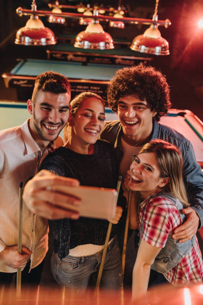 powyżej widok szczęśliwych par robiących selfie z telefonem komórkowym w klubie rozrywki. - pool game snooker pub sport zdjęcia i obrazy z banku zdjęć