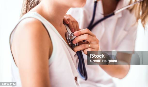 Young Female Doctor Examining A Small Girl In Her Office Stock Photo - Download Image Now
