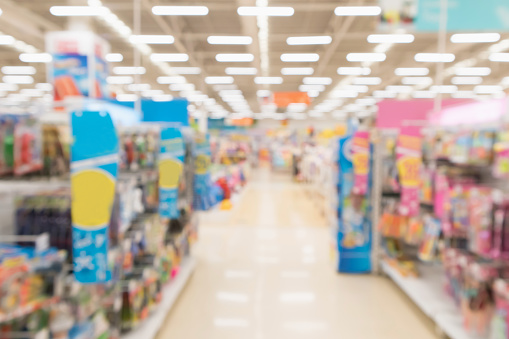 Abstract blur empty supermarket discount store aisle and product shelves interior defocused background