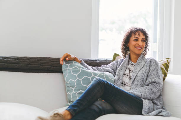 istock Smiling mature woman relaxing on sofa at home 926084600