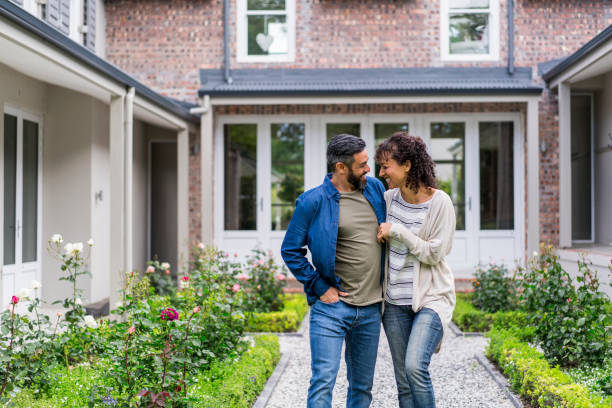 istock Happy couple walking on footpath against house 926085092