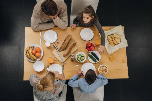 Above view of young family eating at dining table.