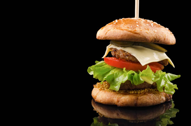 istock Big single cheeseburger isolated on black background with space for text 926089784