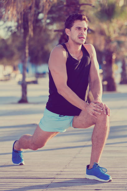 istock Male athlete stretching legs after strength training 926092334