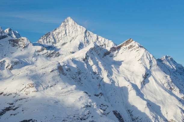 istock A Swiss mountain across a valley filled with snow 926093098