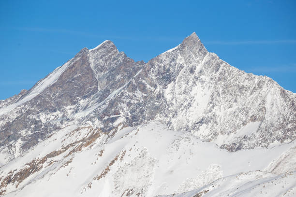 istock A Swiss mountain across a valley filled with snow 926093108