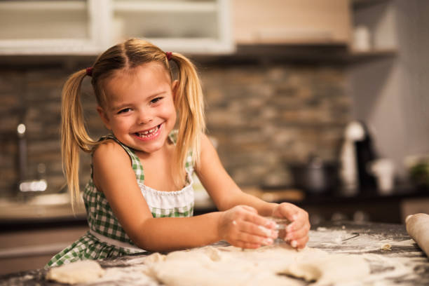 istock Small girl enjoying while making a cake in the kitchen. 926095986