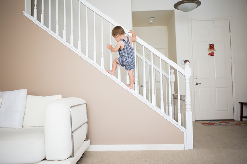Active toddler boy is unsafe in staircase.