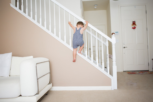 Active toddler boy is unsafe in staircase.