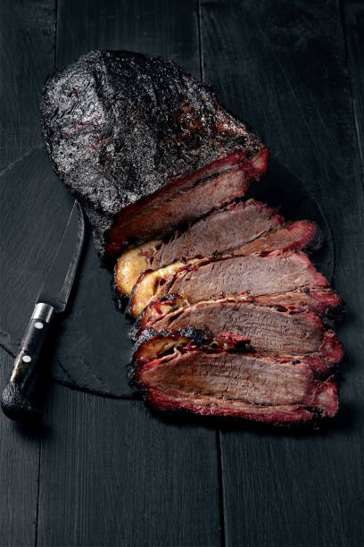 Fresh Brisket BBQ beef sliced for serving against a dark background Fresh Brisket BBQ beef sliced for serving against a dark background. Generous accommodation for copy space. American style brisket photos stock pictures, royalty-free photos & images