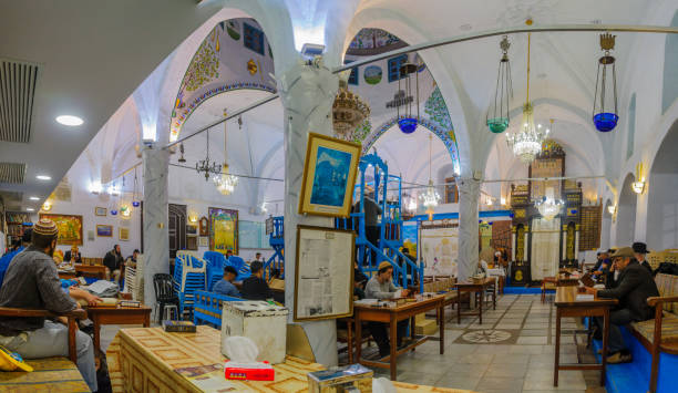 Purim 2018 in the old Abuhav synagogue, Safed (Tzfat) SAFED, ISRAEL - FEB 28, 2018: Traditional Purim (Jewish Holiday) in the old Abuhav synagogue with prayers, some in costumes, attend a reading of the megillah (Scroll of Esther). Safed (Tzfat), Israel esther bible stock pictures, royalty-free photos & images