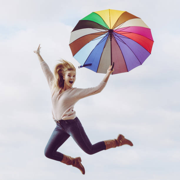 istock Funny woman jumping with umbrella 926101232