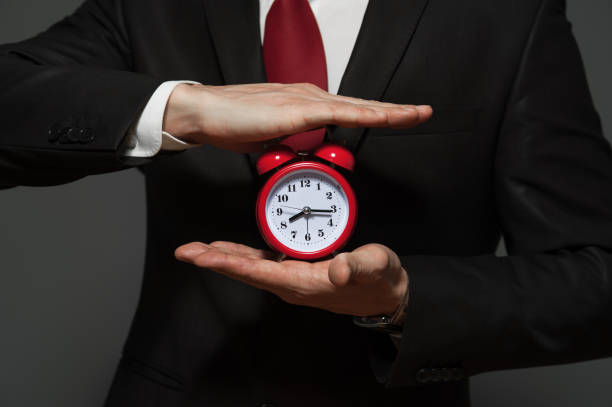 istock Handsome businessman in formal suit holding clock 926101814