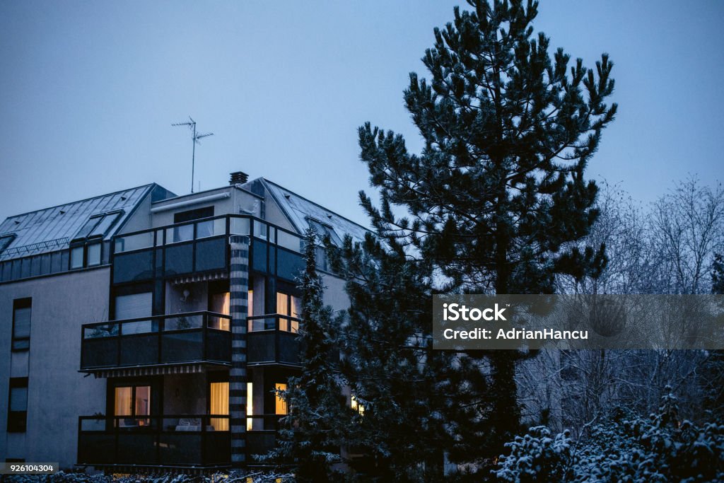 Appartamento moderno con una luce accesa sulla seconda e sulla terza finestra - Foto stock royalty-free di Notte