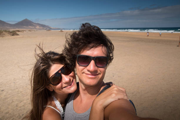 Happy couple at Cofete beach, Fuerteventura. Selfie. stock photo