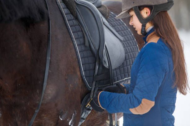 istock Young girl adjusting stirrups before riding horse 926113214