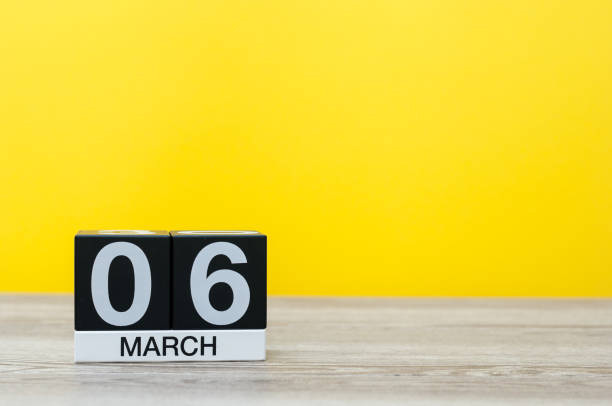 istock March 6th. Day 6 of month, calendar on table with yellow background. Spring time, empty space for text 926116746