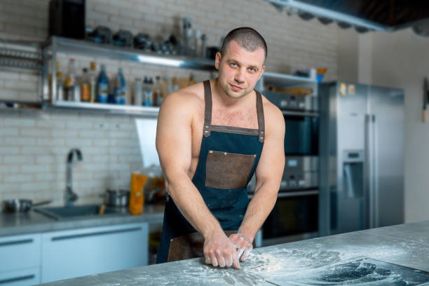 chef de fisiculturista no hotel ou restaurante cozinha sove a massa sobre a mesa. cozinhar pizza. processo de cozimento - bread kneading making human hand - fotografias e filmes do acervo