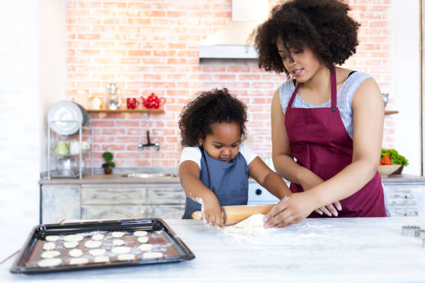 istock Mother and daughter using metal molds for making homemade biscuits 926125328
