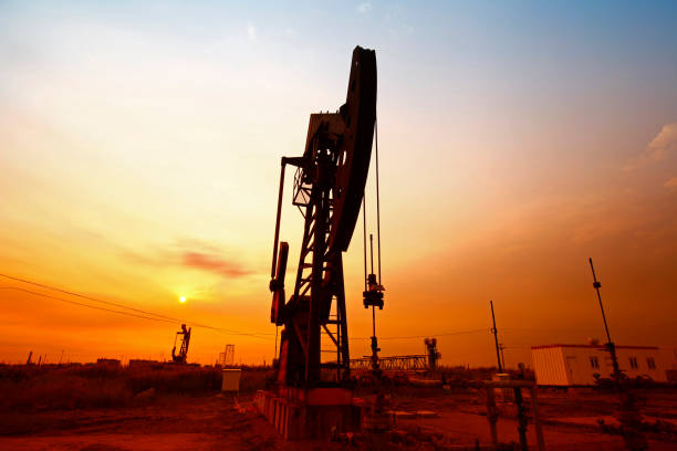 tempo do sol da bomba de óleo, equipamentos de indústria de petróleo - oil pumping unit at sunset time - fotografias e filmes do acervo