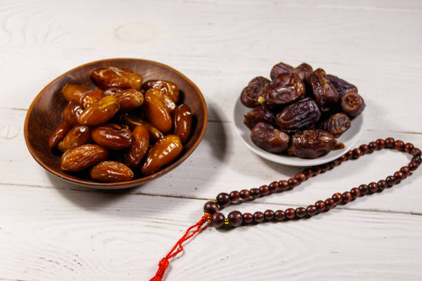 istock Dates fruit and prayer beads on white wooden table 926135574