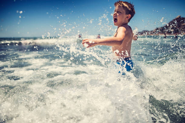 istock Little boy splashing in sea on summer day 926136626