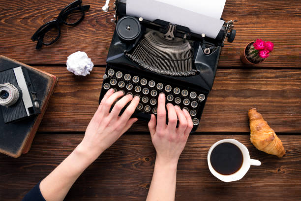 woman writing on an old typewriter - author writing retro revival women imagens e fotografias de stock