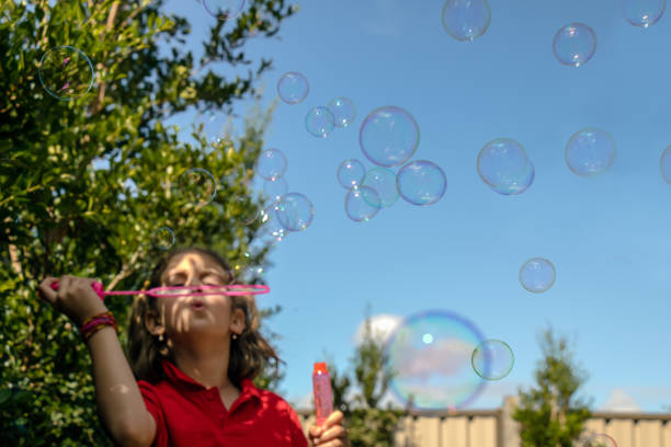istock A girl blowing bubbles in the air 926142998