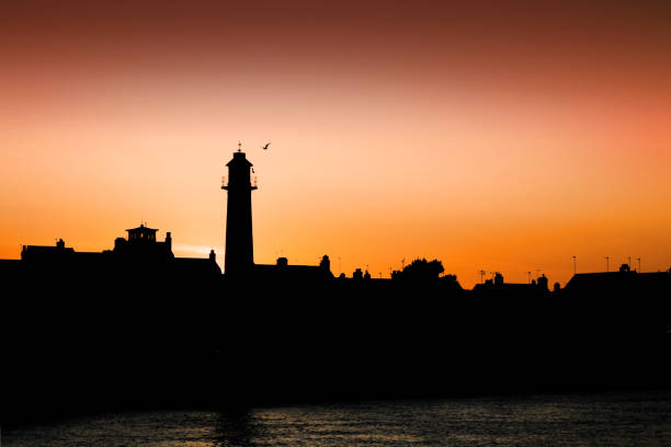 sunset behind the lighthouse at gorleston-on-sea - great yarmouth england norfolk river imagens e fotografias de stock