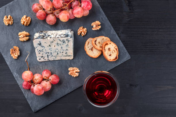 istock Blue cheese, grapes, and wine on black with copy space 926147788