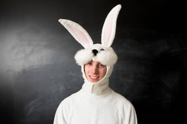 hombre cansado en un traje de conejo blanco - disfraz de conejo fotografías e imágenes de stock