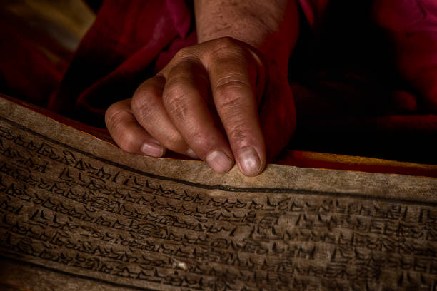 istock Hands of a Tibetan monk with an ancient prayer book 926152650